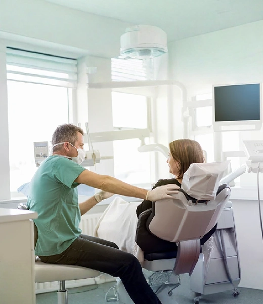 Dentist talking with a patient in the dental chair