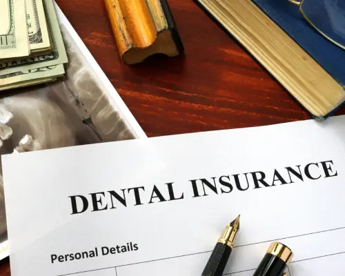 Dental insurance claim form next to a model of teeth
