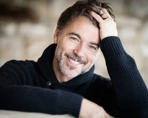 Relaxed smiling man resting his head on his hand