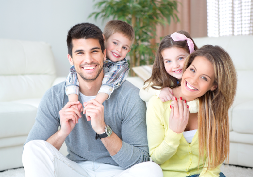 Smiling family of four sitting together at home