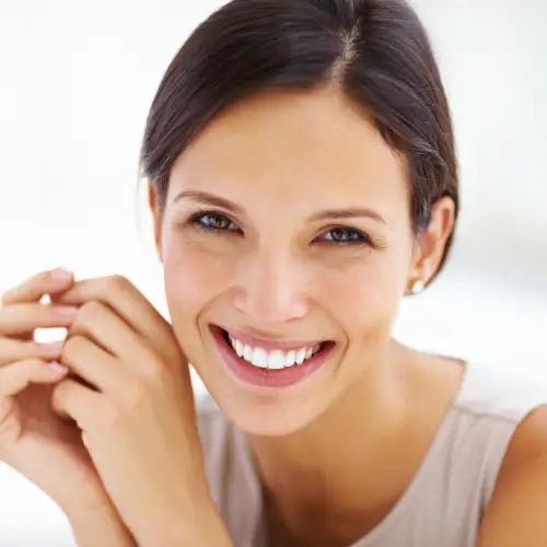 Smiling woman with dark hair showing white, even teeth