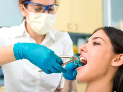 Dentist gently extracting a tooth for a patient