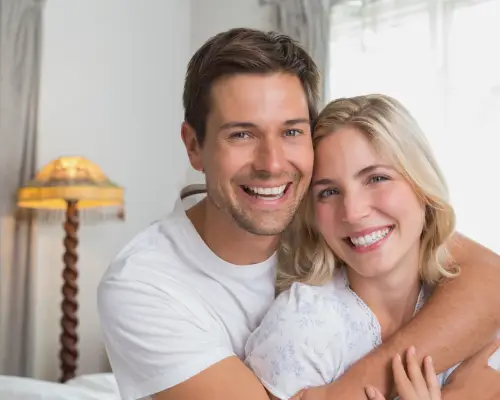 Smiling young couple embracing at home